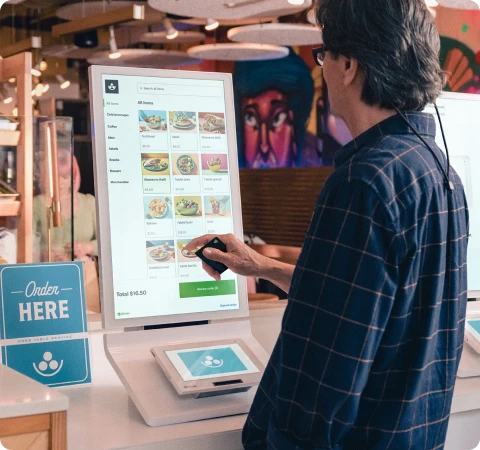 Clover self-order kiosk with Order Here sign